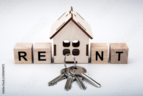 miniature house with wooden cubes with inscription rent and door keys