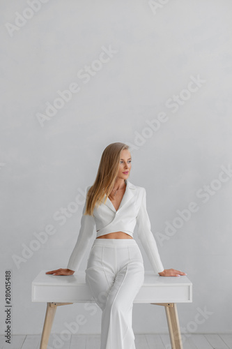 Young beautiful girl in a white business suit