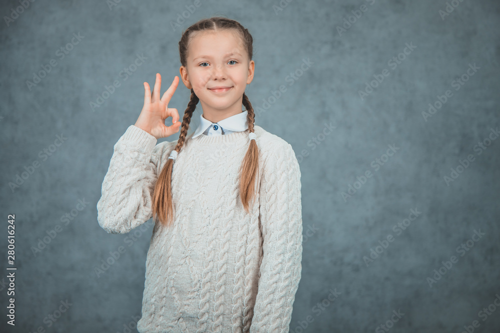 The young attractive blond schoolgirl makes ok gesture The young attractive blond schoolgirl makes ok gesture