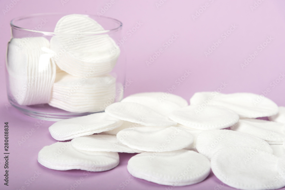 Cotton sponge on a pink background with a glass jar Cotton sponge on a pink background with a glass jar