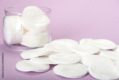 Cotton sponge on a pink background with a glass jar