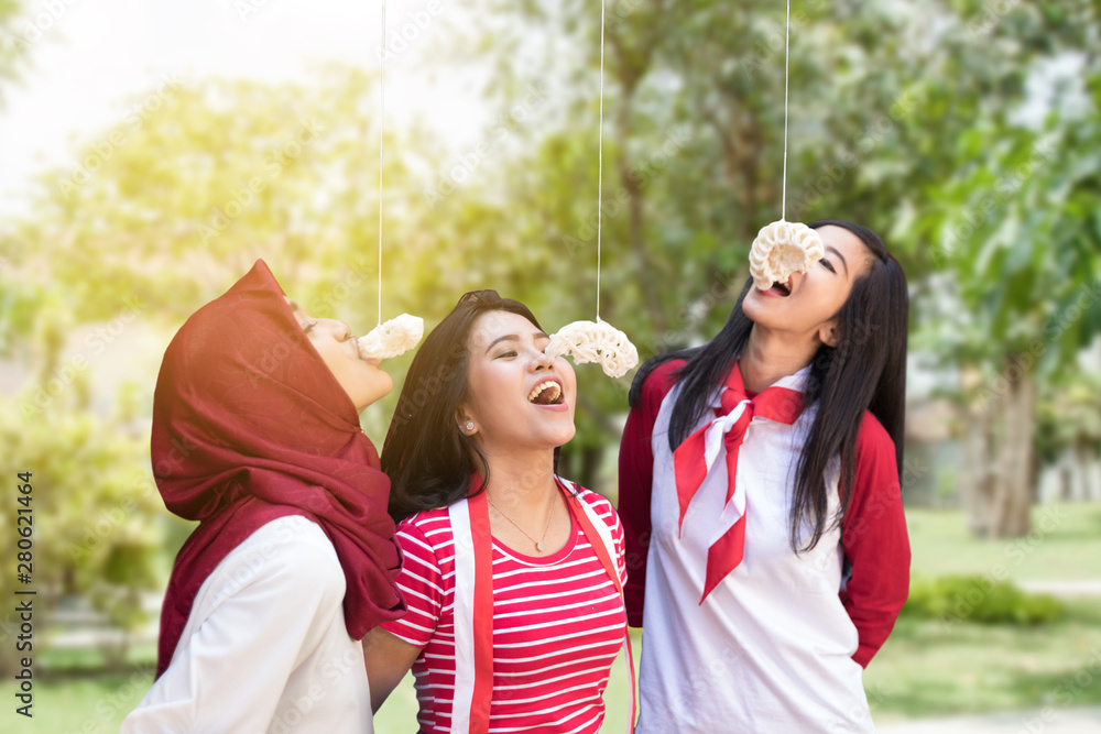 Fototapeta premium portrait of indonesia crackers eating competition on independence day celebration