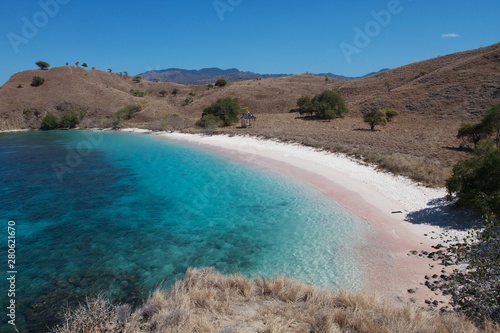 Pink sand beach and clear turquoise sea water in the Komodo National park, Indonesia 