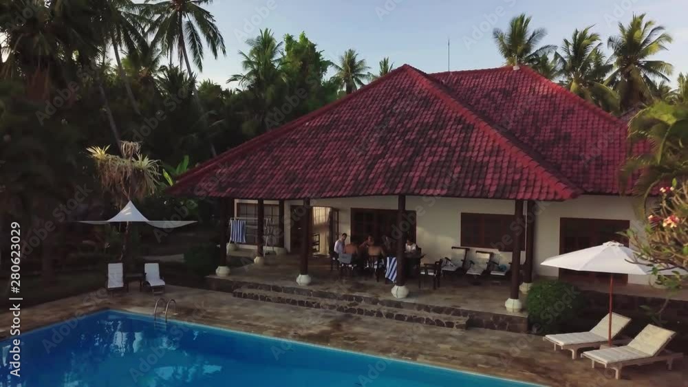 custom made wallpaper toronto digitalAerial flight away from a group of friends sitting around a table in a luxury villa with swimming pool surrounded by tropical palm trees