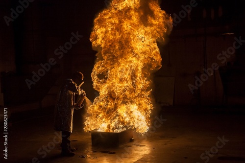 Firefighter extinguishing fire with fire extinguisher photo