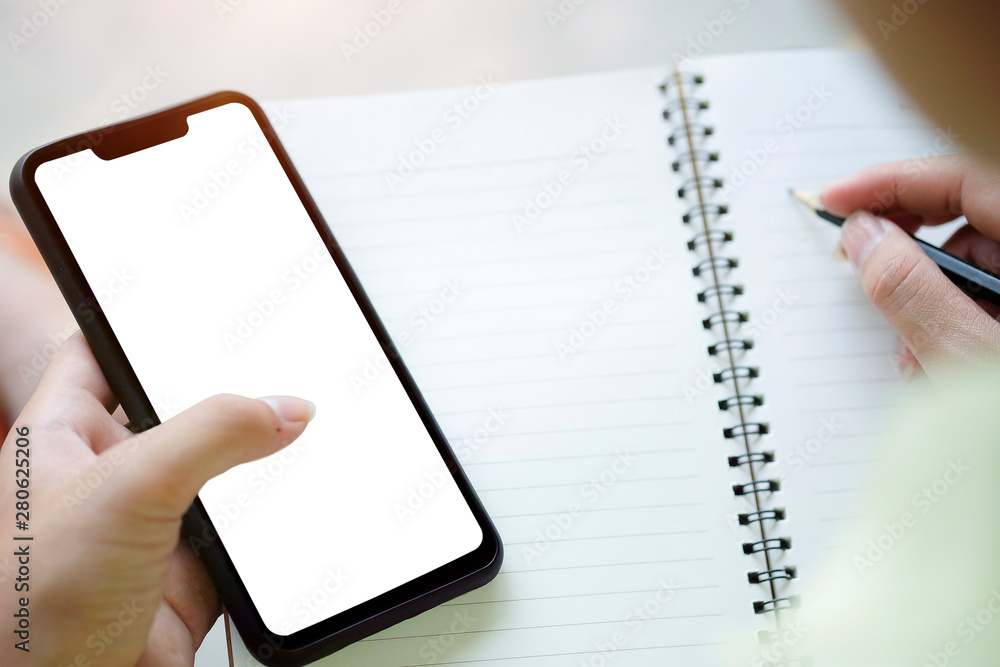 Mock up smartphone of hand holding black mobile phone with blank white screen Mock up smartphone of hand holding black mobile phone with blank white screen