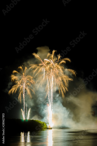 Colorful fireworks. Fireworks are a class of explosive pyrotechnic devices used for aesthetic and entertainment purposes. Visible noise due to low light, soft focus, shallow DOF, slight motion blur © shahrilkhmd