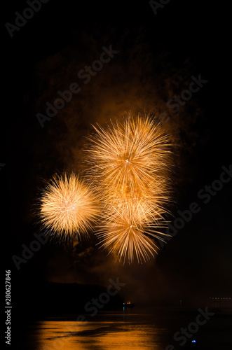 Colorful fireworks. Fireworks are a class of explosive pyrotechnic devices used for aesthetic and entertainment purposes. Visible noise due to low light  soft focus  shallow DOF  slight motion blur