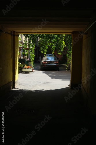 light yard with the car and greenery at end of the arch in Saint Petersburg russia