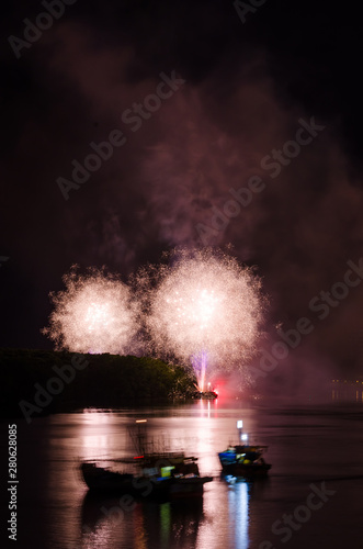 Colorful fireworks. Fireworks are a class of explosive pyrotechnic devices used for aesthetic and entertainment purposes. Visible noise due to low light  soft focus  shallow DOF  slight motion blur