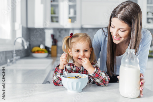 Mother preparing breakfast for her daughter