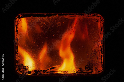 View through the glass on the fire in the furnace