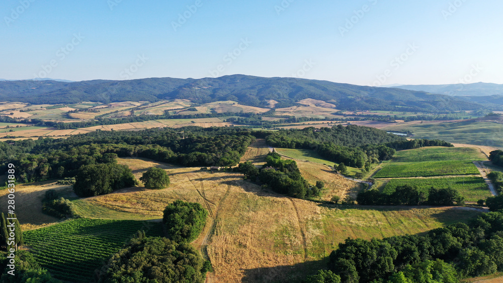 Naklejka premium Aerial view of Tuscany landscape, Val d’Orcia, Italy. Golden and green glades, road with cypress trees at sunset.