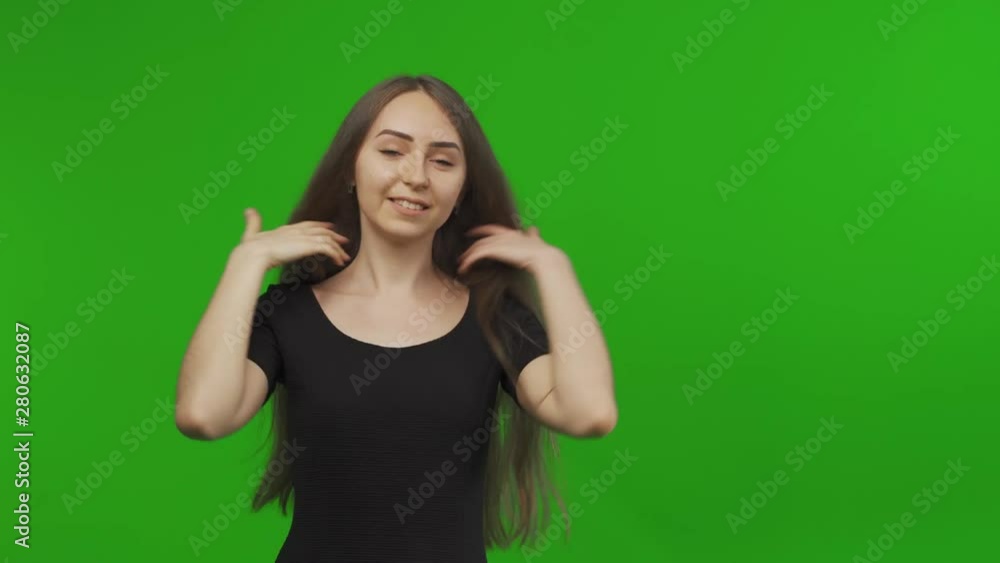 Young positive smiling woman show thumbs up to the camera on green screen. Pretty student teenager gesturing. Chroma key background Young positive smiling woman show thumbs up to the camera on green screen. Pretty student teenager gesturing. Chroma key background