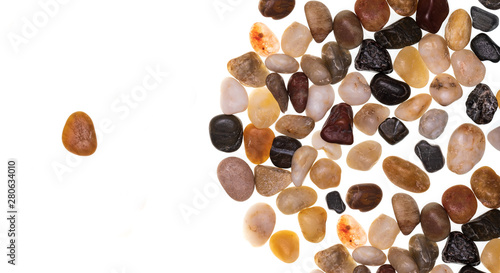 Leadership concept (the group follows the leader) made with a group of multi-colored stones (multicolored). Multidisciplinary and multiracial group concept. Isolated on white background.