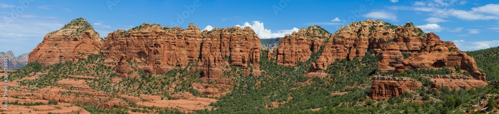 Panoramic landscape of sandstone rock formations, peaks, and buttes under a beautiful blue sky - view from the Schnebly Hill Road, Sedona, Arizona