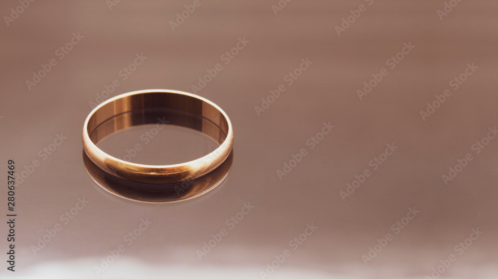 Wedding gold ring with reflection on the glass table. Wedding attribute and marriage proposal. Wedding gold ring with reflection on the glass table. Wedding attribute and marriage proposal.