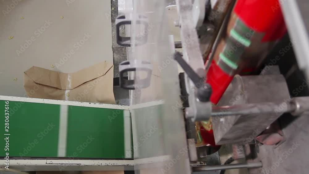 Close up of spaghetti packages running on an automated machinery in a pasta factory. Spaghetti bag passing on a conveyor belt in a pasta factory. Line for packaging pasta in plastic bags. Close up of spaghetti packages running on an automated machinery in a pasta factory. Spaghetti bag passing on a conveyor belt in a pasta factory. Line for packaging pasta in plastic bags.