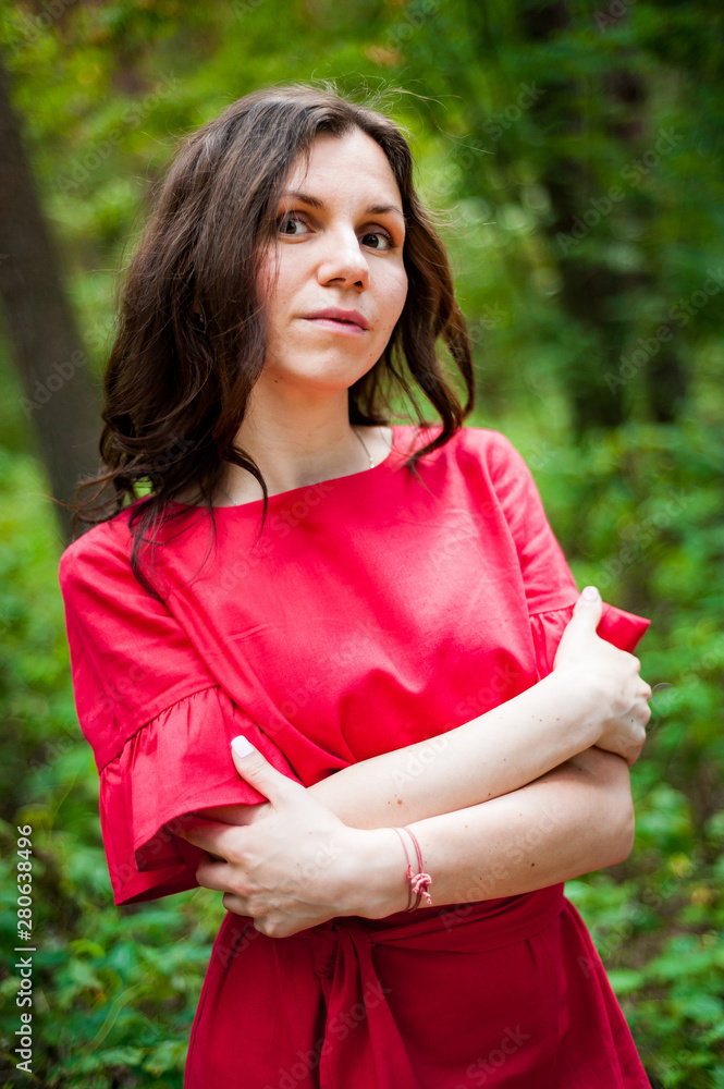 Beautiful brunette in a red dress walking in a Sunny Park Beautiful brunette in a red dress walking in a Sunny Park