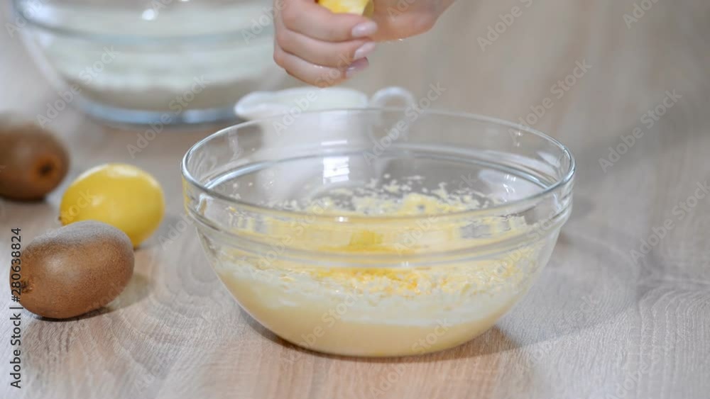 Hands chef squeezes the juice from the lemon to the dough.
