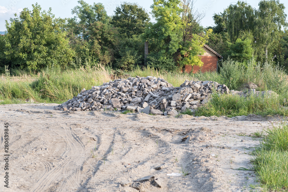 Fototapeta premium Pig pile of tarmac or asphalt road parts cracked and demolished dumped on the sandy field after replacement of old street 