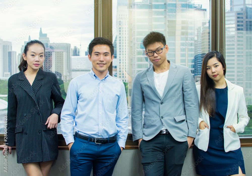Asian business people is posing beside the window Asian business people is posing beside the window