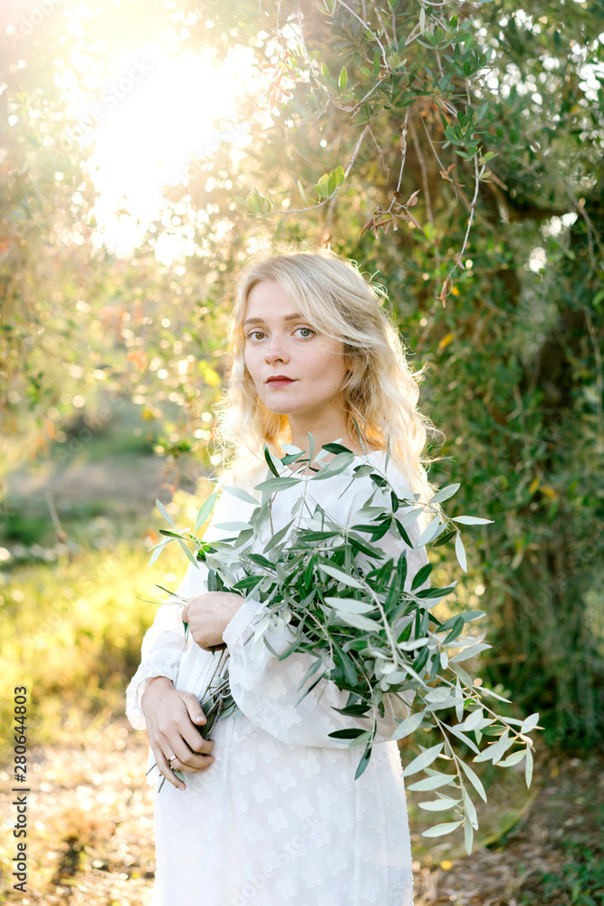 Pregnant lady holding olive branches on sunny day Pregnant lady holding olive branches on sunny day
