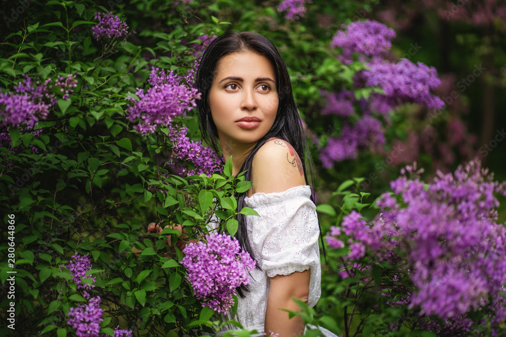 portrait of authentic girl in blooming bush with purple flowers portrait of authentic girl in blooming bush with purple flowers