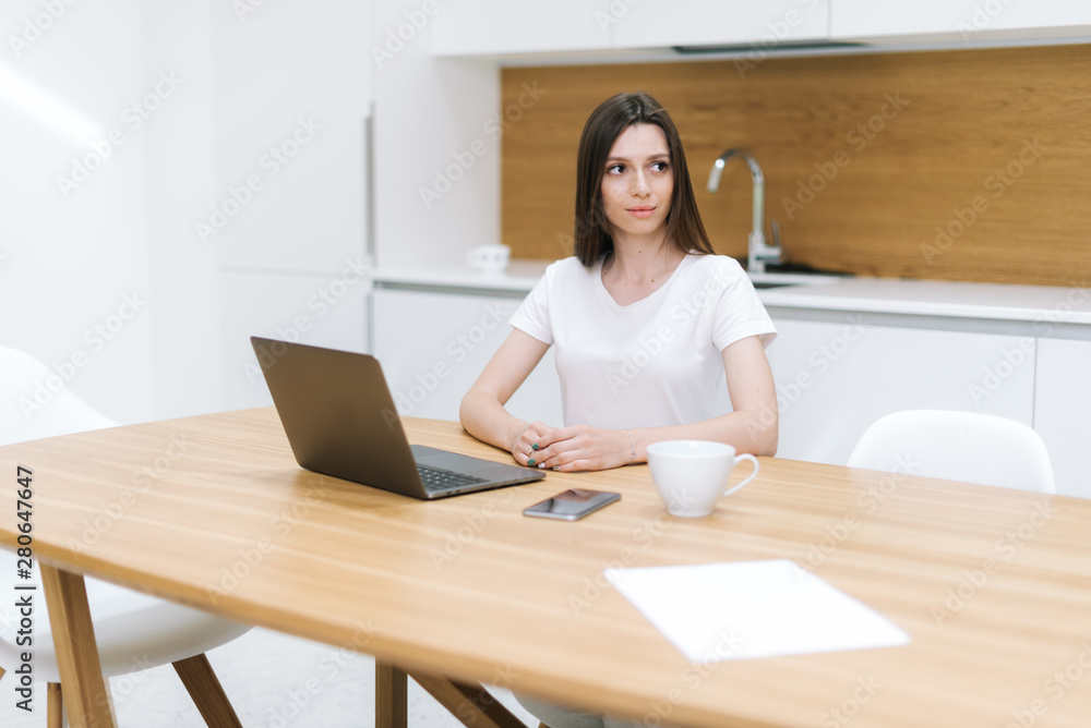 Portrait of thoughtful woman sitting at table and looking away Portrait of thoughtful woman sitting at table and looking away