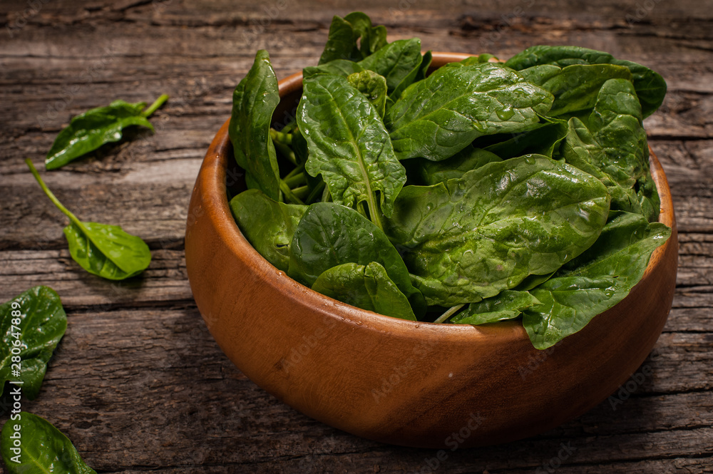 Spinach in a wooden plate on a wooden background Spinach in a wooden plate on a wooden background