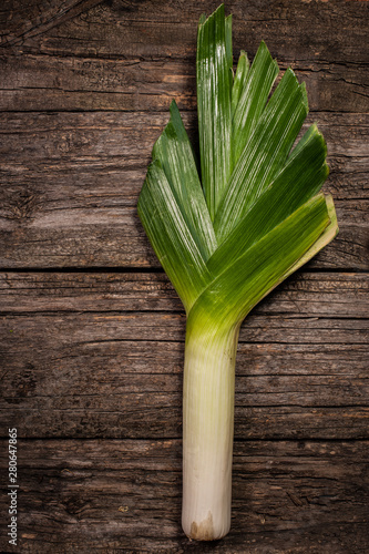 Leeks on rustic background top view vertical