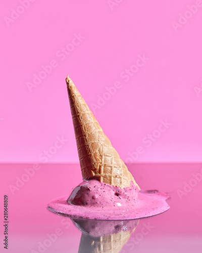 Scoops of berry melting ice cream in wafer cones are reflected o