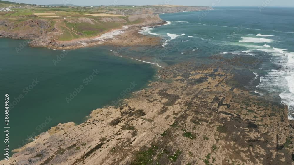 Aerial view of waves crashing onto a rocky coastline at Worm's Head on the Gower peninsula of Wales Aerial view of waves crashing onto a rocky coastline at Worm's Head on the Gower peninsula of Wales