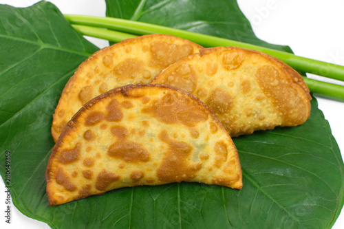 Tradional Brazilian fried pastry called pastel on Exotic edible plant  leafcalled taioba photo