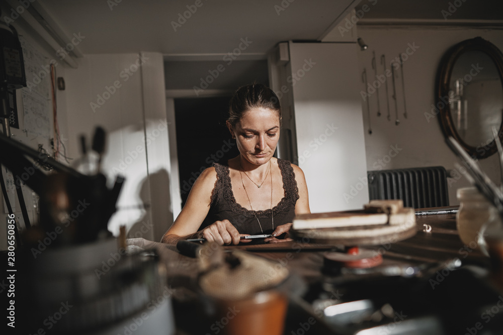 Female jeweler using calipers to make precision measurements Female jeweler using calipers to make precision measurements