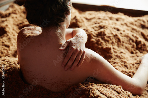 Woman soaking and exfoliating her skin in fermented Japanese cedar enzyme bath