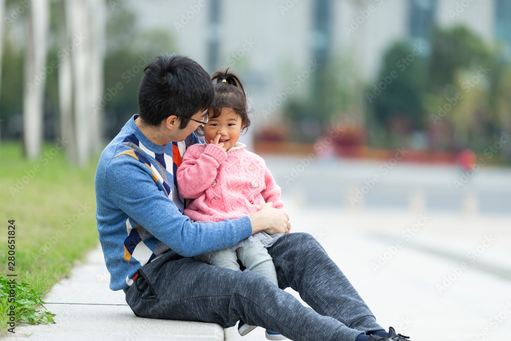 Asian father holding her little girl outdoor in the park Asian father holding her little girl outdoor in the park