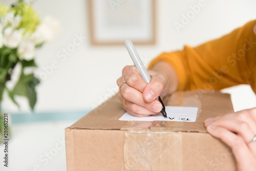 Woman writing address on package