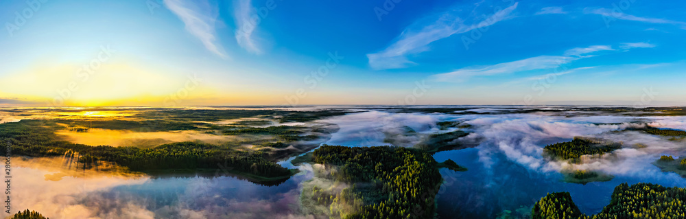 Sun rises on horizon, panoramic landscape. Beautiful morning in green forest near lakes. Environment concept