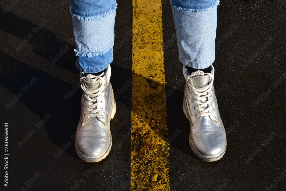 Women's silver boots and blue jeans.