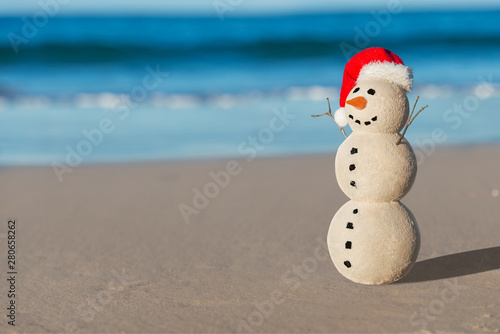 Christmas Sandy Snowman on a beautiful sand beach - Christmas symbol of countries where the weather is always warm