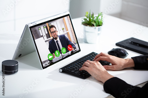 Cropped image of businesswoman using laptop at desk photo