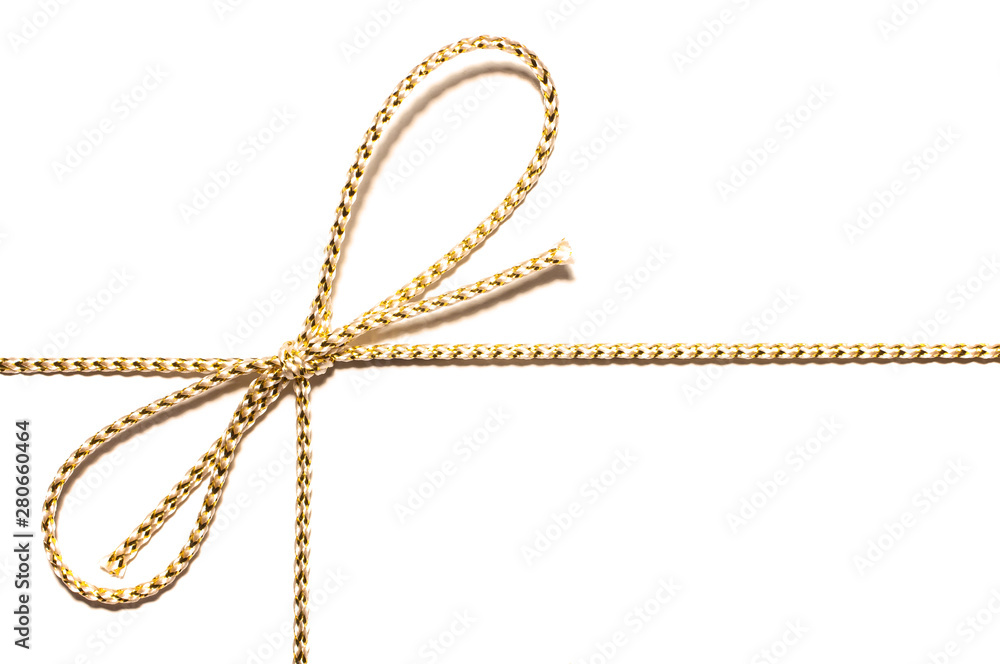 Golden satin rope with knotted bow gift ribbon wrap for Christmas present with intricate shine details isolated cut out top view on simple plain white background. Golden satin rope with knotted bow gift ribbon wrap for Christmas present with intricate shine details isolated cut out top view on simple plain white background.
