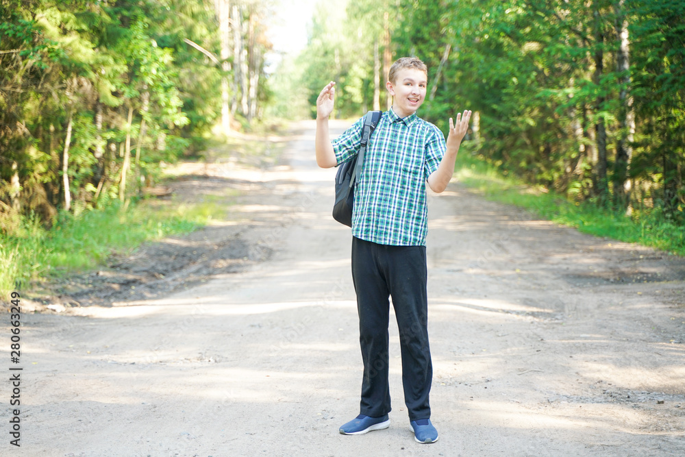 teenager boy walking in the forest alone in the summer day teenager boy walking in the forest alone in the summer day