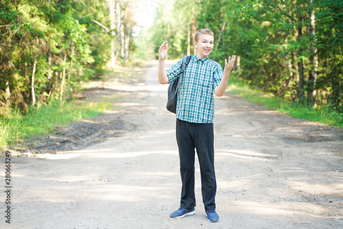 teenager boy walking in the forest alone in the summer day
