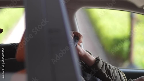 Close-up of male criminal strangling driver with safety belt. Murderer using seat belt as stranglehold while taxi man putting hand under noose and turning to beat the mugger