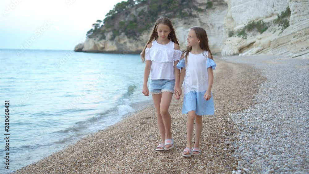 Little girls having fun at tropical beach during summer vacation Little girls having fun at tropical beach during summer vacation