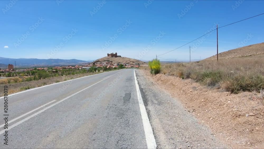 a paved road approaching La Calahorra town, Province of Granada, Andalusia, Spain a paved road approaching La Calahorra town, Province of Granada, Andalusia, Spain
