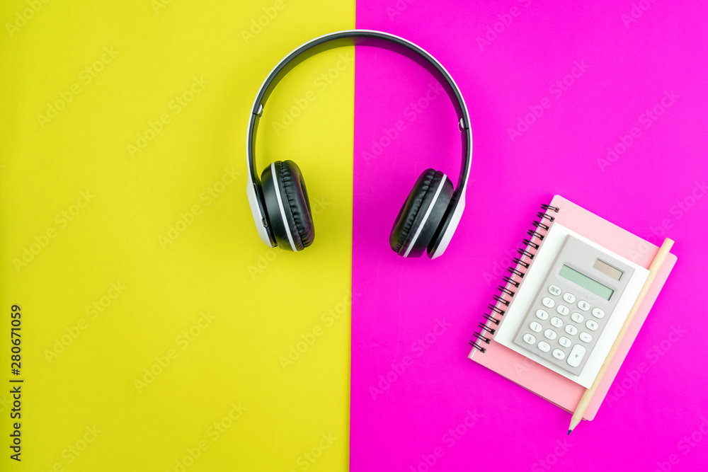 Headphone with Business paper note,pencil and business objects on colorful paper background Headphone with Business paper note,pencil and business objects on colorful paper background