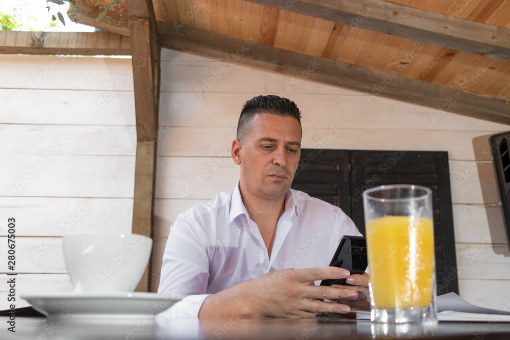 man drinking coffee in cafe and looking in mobile phone very concern man drinking coffee in cafe and looking in mobile phone very concern